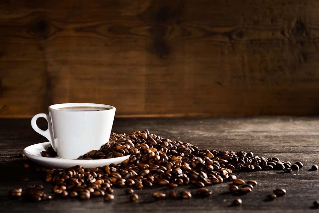 Taza y granos de café sobre un fondo de madera